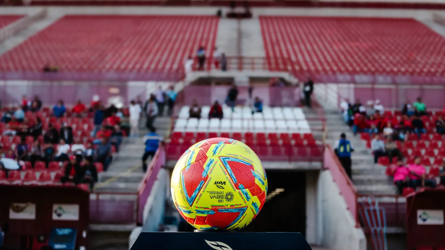 Pallone in primo piano con le tribune dello stadio sullo sfondo
